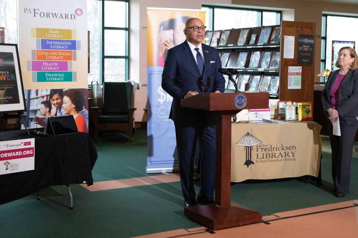 Auditor General Timothy L. DeFoor stands at podium in library